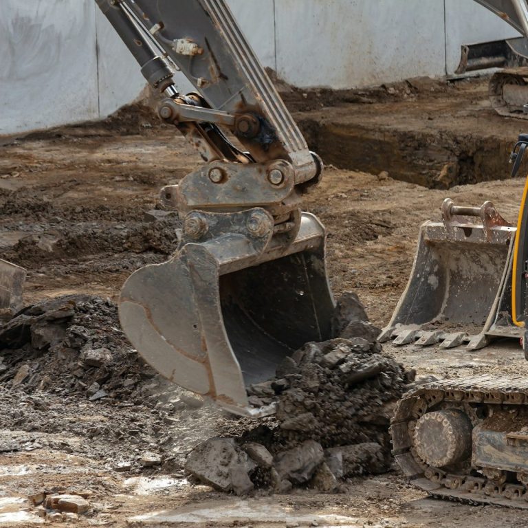 Bagger beim Ausheben von Erde auf einer Baustelle. Tiefbauarbeiten im Rhein Sieg Kreis.